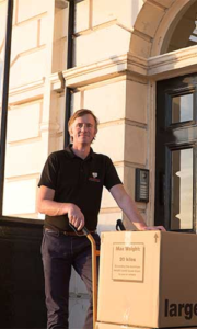 Removal worker with moving box outside home