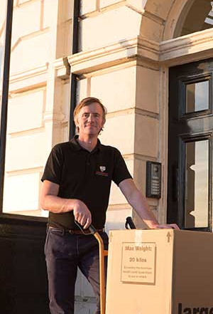 Removal worker with moving box outside home